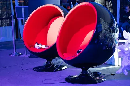 Participant installé dans un siège œuf avec casque VR pour une immersion voyage en réalité virtuelle