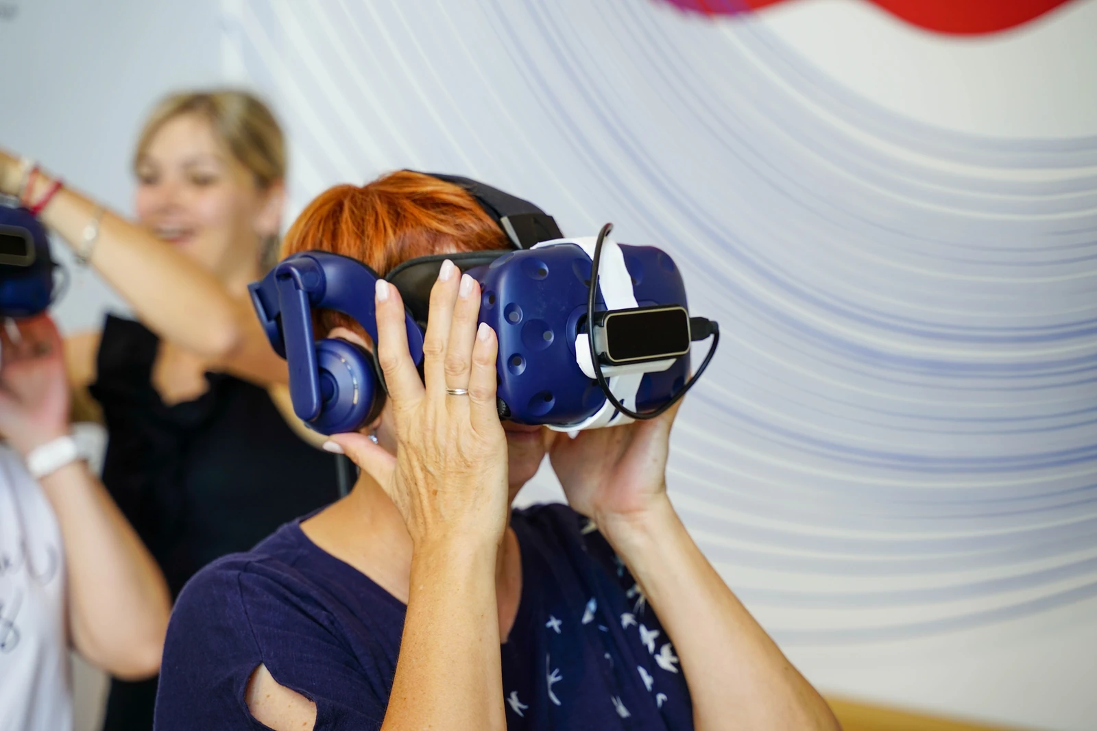 Femme avec un casque VR bleu et ses collègues lors d'une animation incentive en entreprise