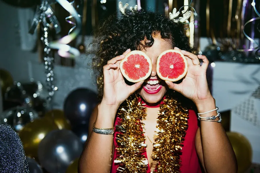 Femme souriante avec accessoires festifs lors d'une fête de fin d'année en entreprise