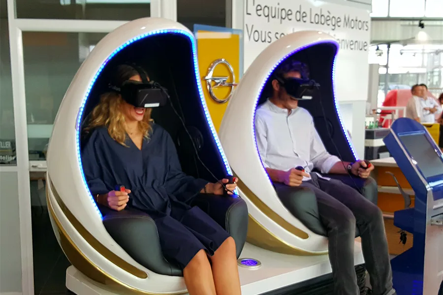 Deux participants assis dans des capsules VR lors d'un salon professionnel