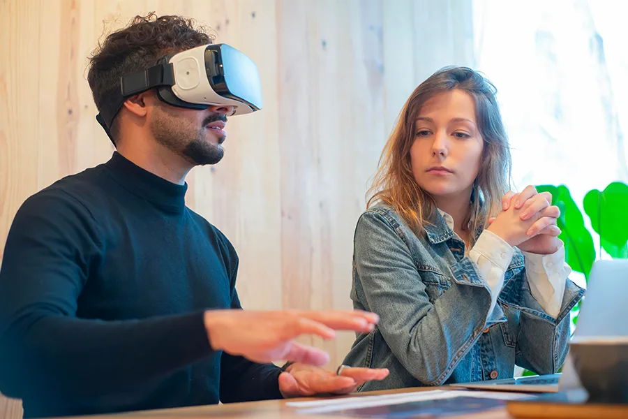 Homme au bureau testant un casque de réalité virtuelle dans un environnement de travail
