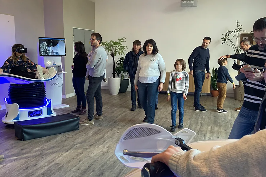 Visiteurs observant une démonstration de simulateurs VR en showroom