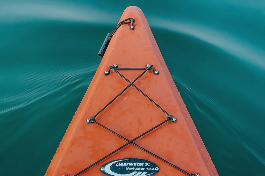 Kayak gonflable orange sur fond d'eau turquoise vu depuis le cockpit avec casque VR et écran de contrôle