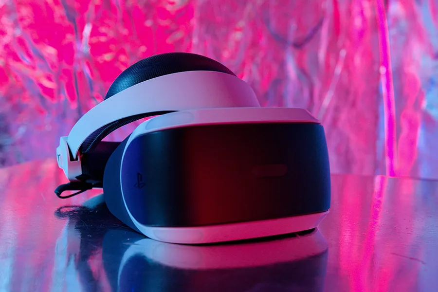 Casque PlayStation VR posé sur une surface noire avec un éclairage rose et bleu