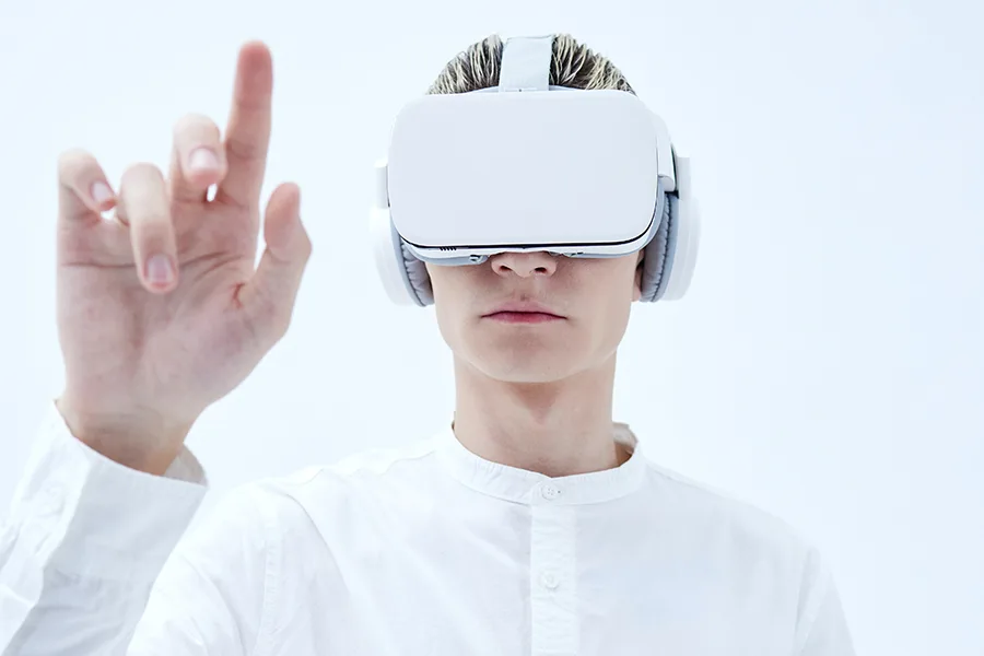 Visiteur portant un casque VR et un casque audio interagissant du doigt avec un contenu virtuel