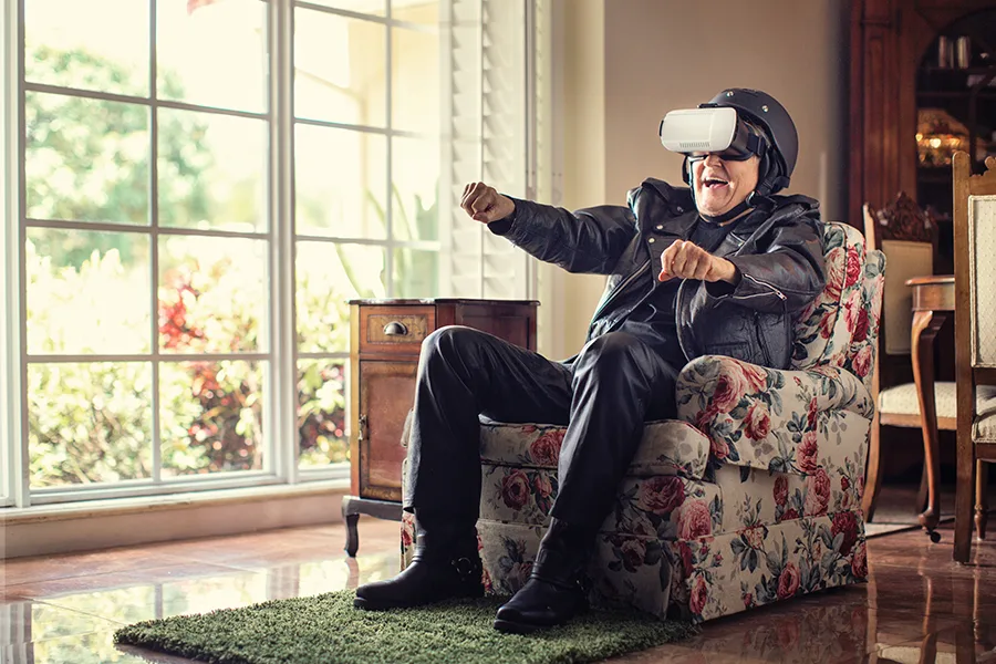 Homme assis dans un fauteuil avec un casque VR, immergé dans un environnement virtuel