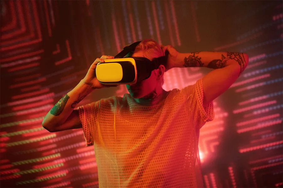 Homme portant un casque de réalité virtuelle jaune sur fond lumineux