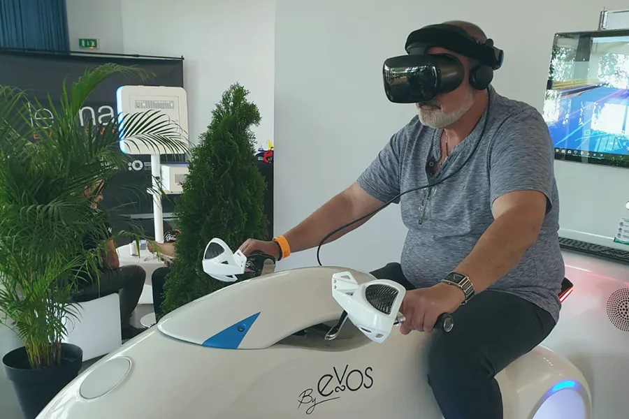 Visiteur testant le simulateur moto VR sur le stand By Evos