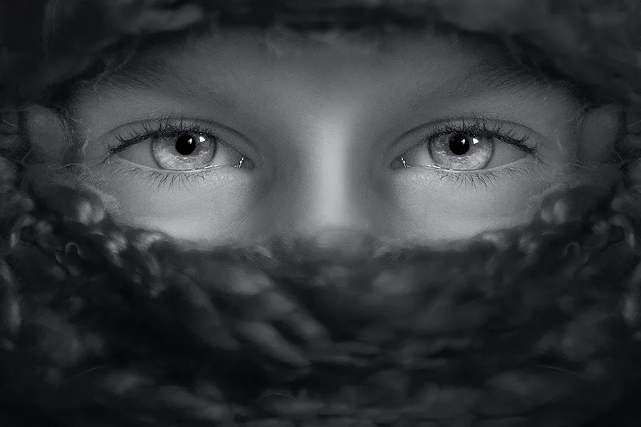 Gros plan en noir et blanc sur des yeux regardant à travers de la fumée