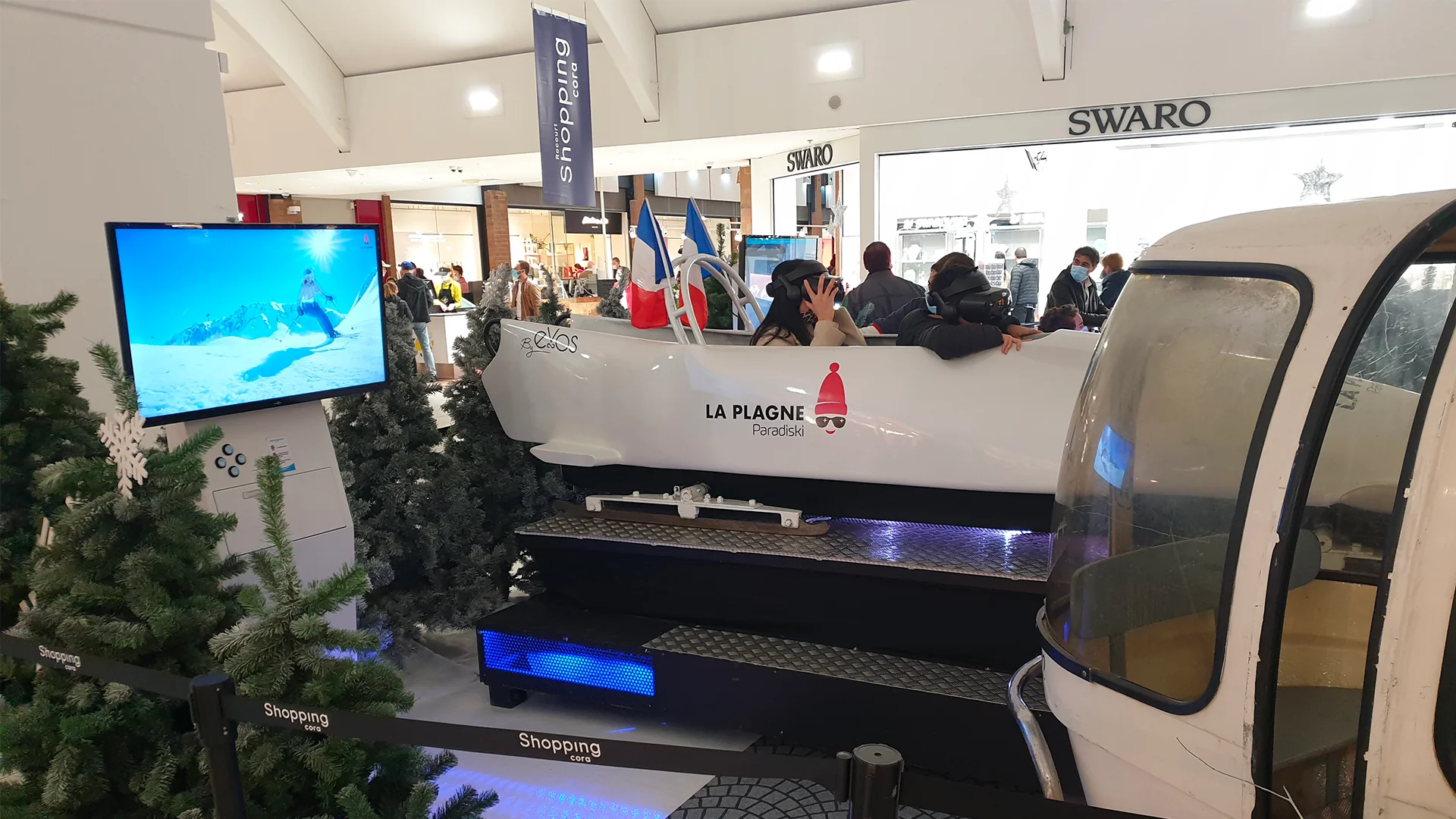 Simulateur VR installé dans un centre commercial avec visiteurs en file d'attente