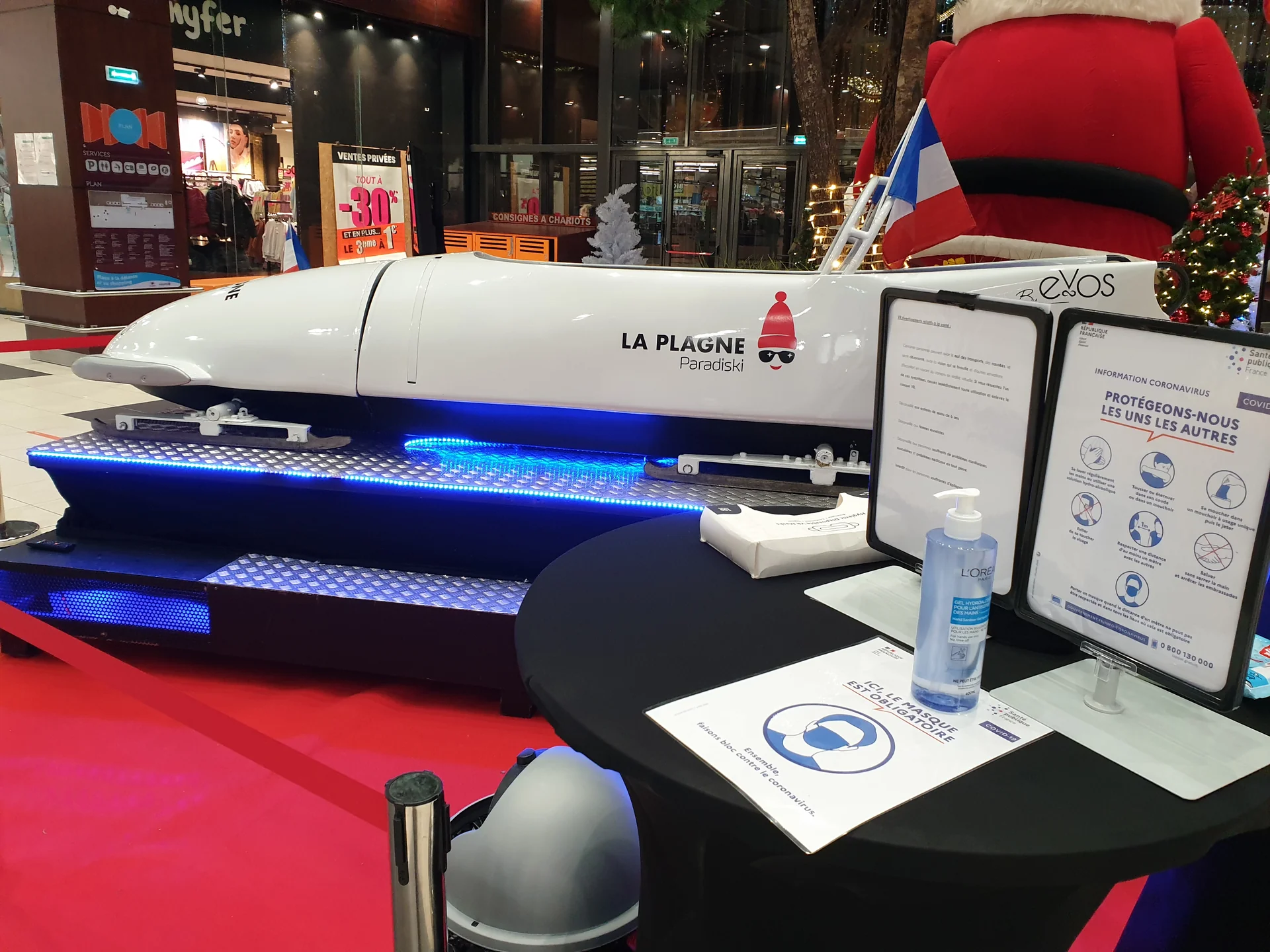 Table d'accueil avec gel hydroalcoolique et affichage Protégeons-nous les uns les autres au pied du bobsleigh