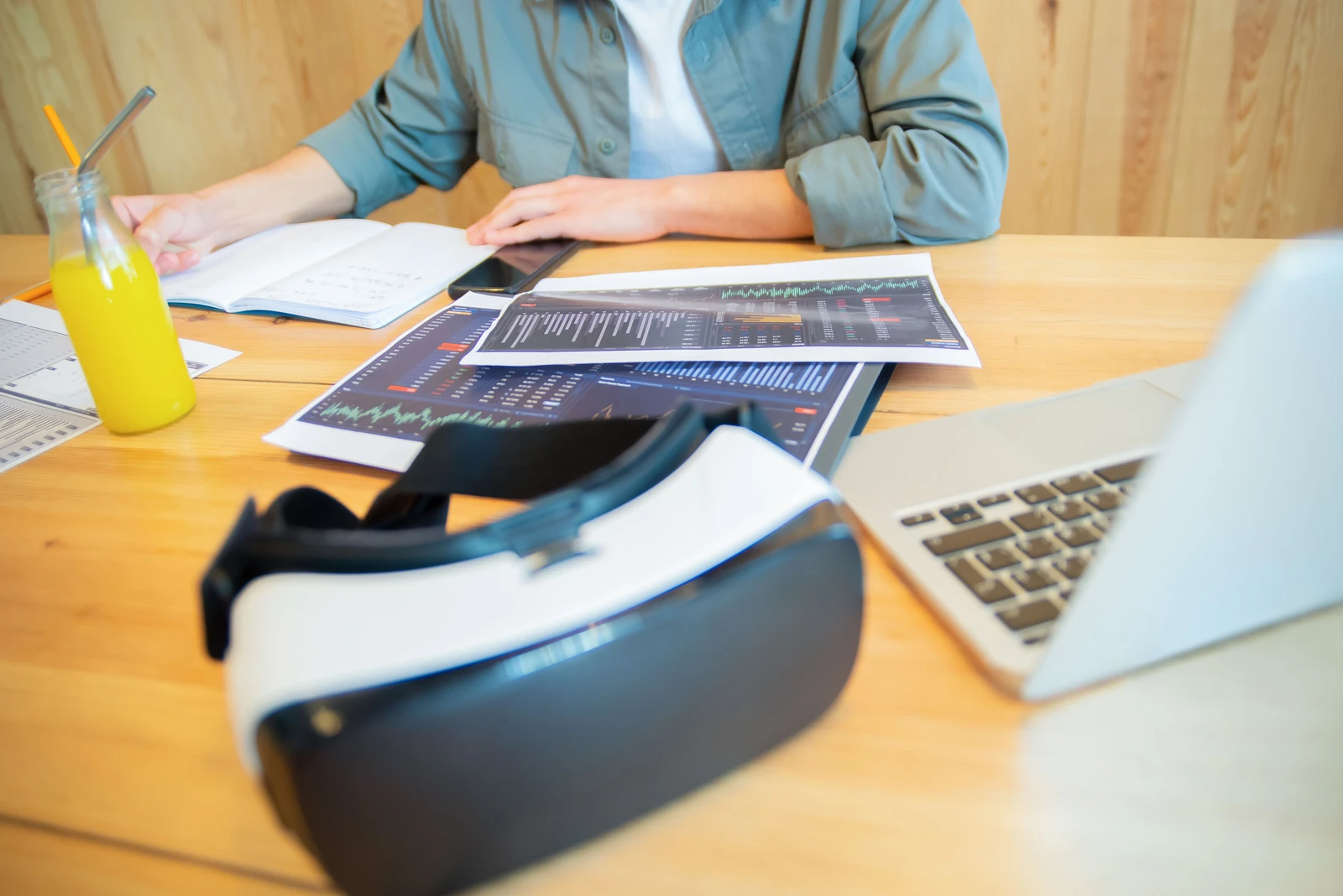 Casque VR posé sur un bureau avec des tableaux de performance et un ordinateur