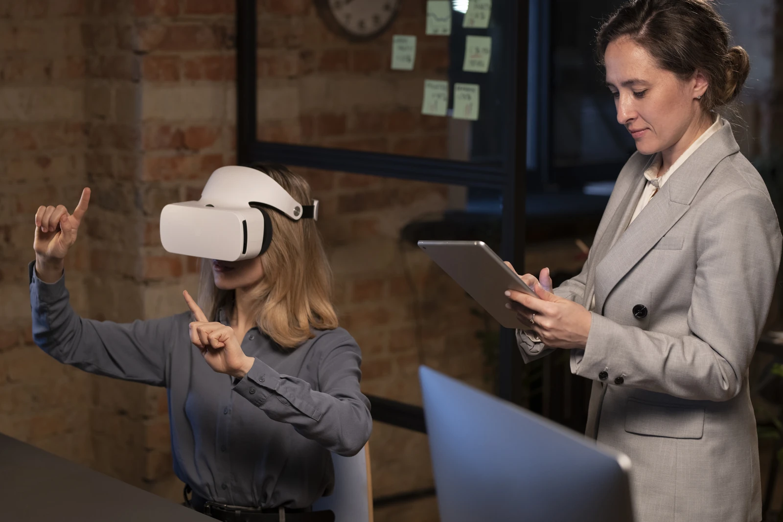 Candidate équipée d'un casque VR évaluée par une recruteuse avec tablette lors d'un entretien immersif