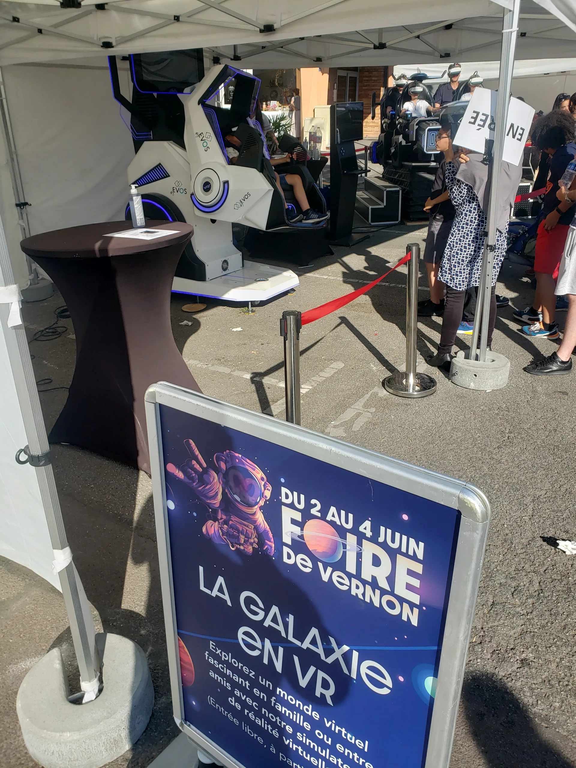 Kakémono thématique Galaxie en VR à côté d'un simulateur scooter blanc à LED bleues sous barnum à Vernon