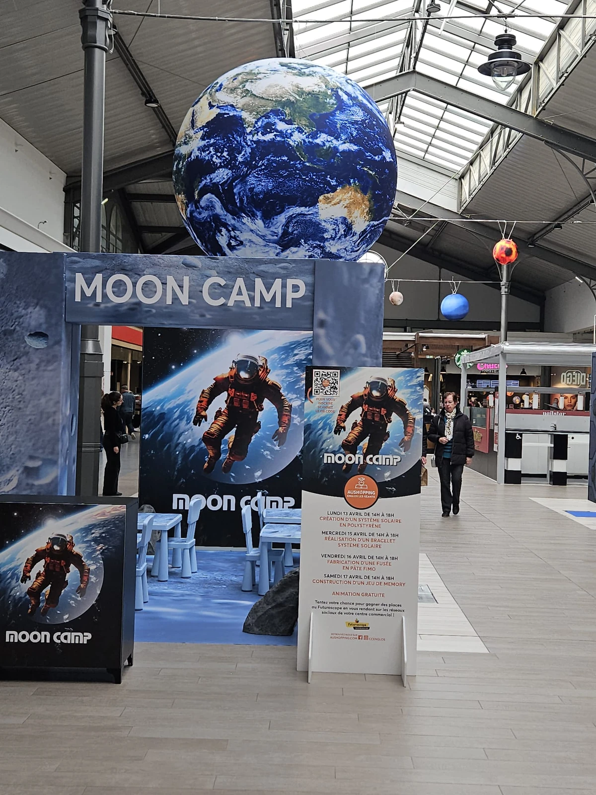 Décor spatial Aushopping Englos avec globe terrestre géant et arche d'entrée animation vacances