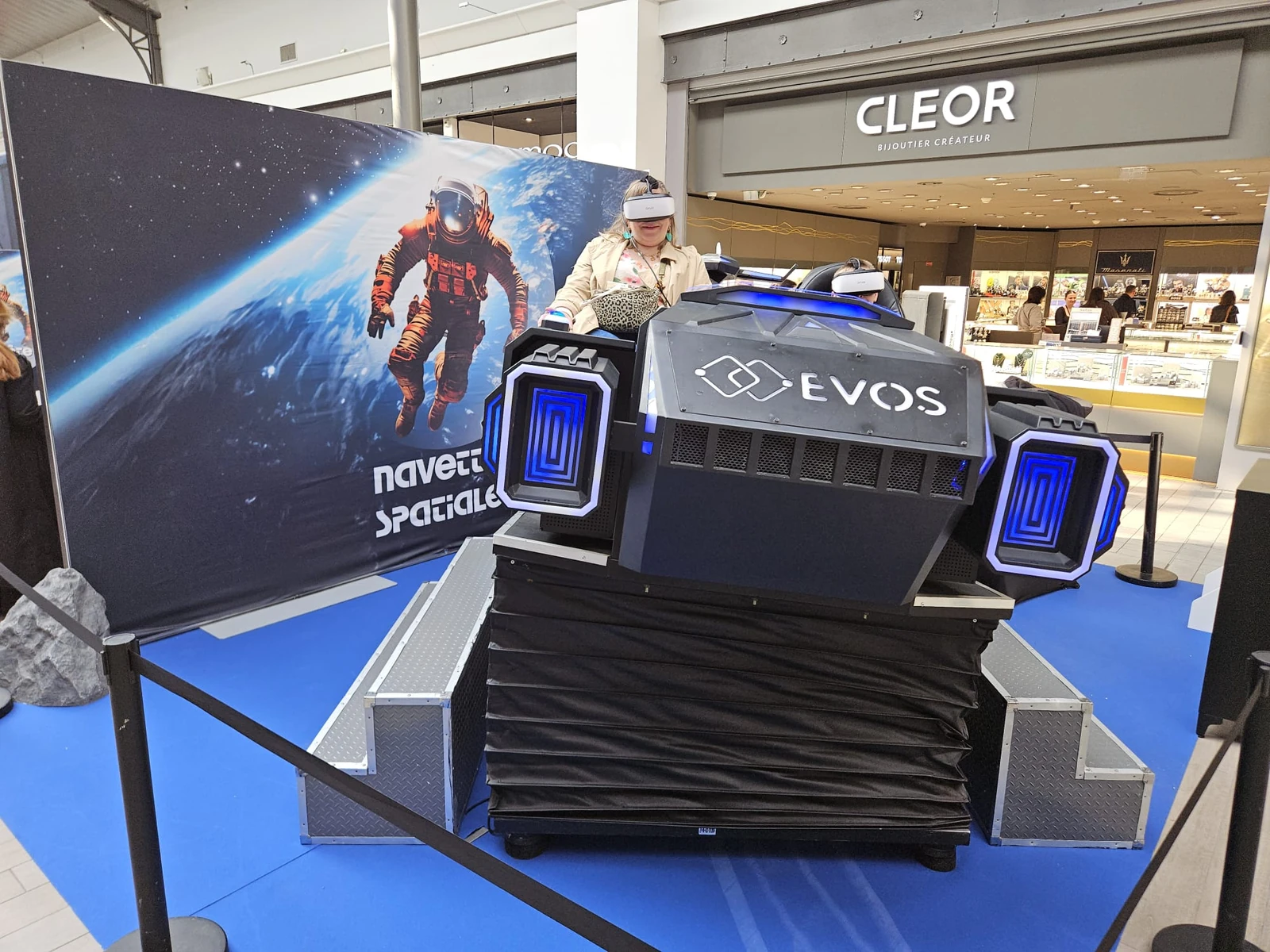 Simulateur navette VR avec participante en casque devant bijouterie Cleor à Englos