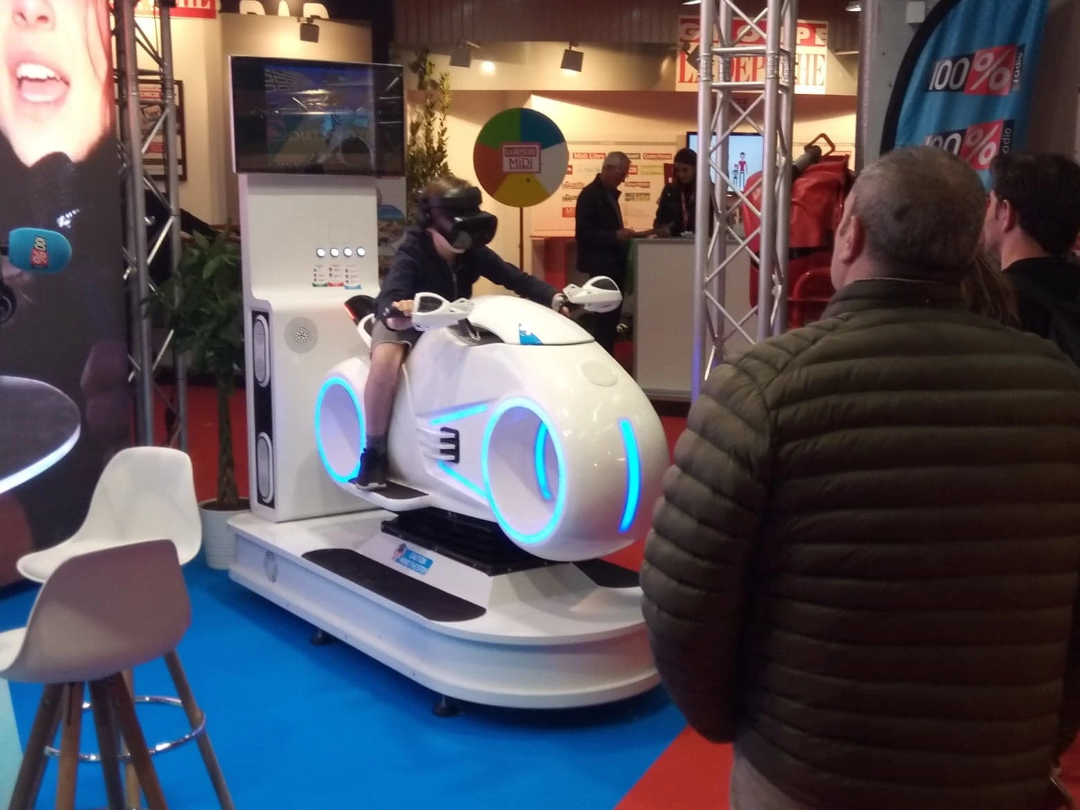 Participant sur un simulateur moto VR sur un stand de salon professionnel By Evos