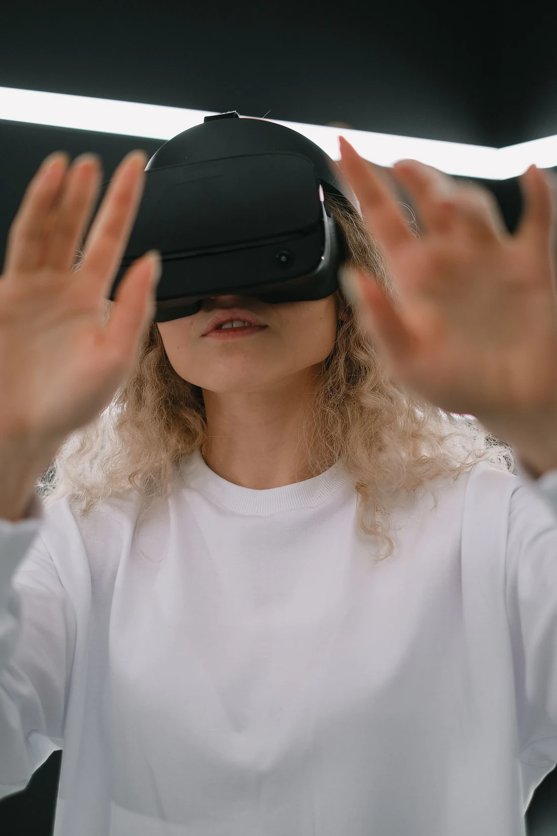 Collaboratrice en immersion VR les mains tendues lors d'une session gamifiée