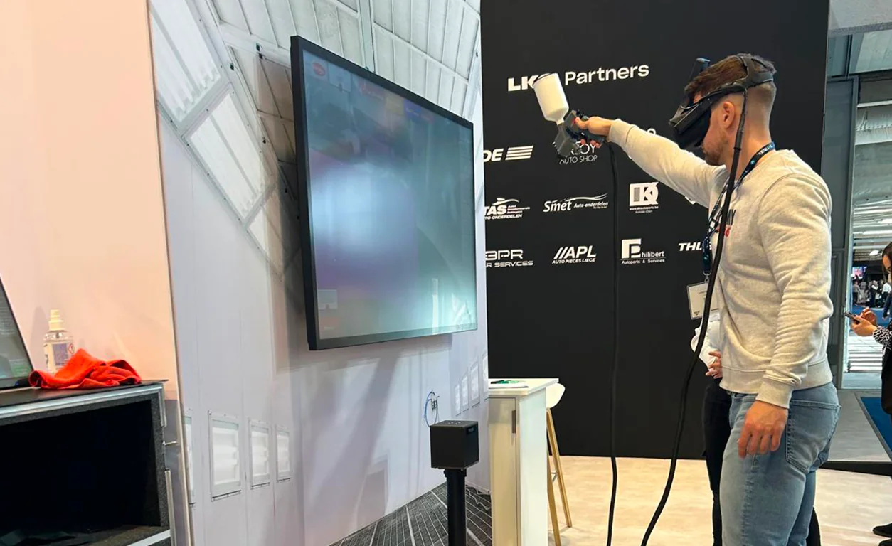 Stand SimSpray By Evos lors d'un salon professionnel avec visiteurs en file d'attente