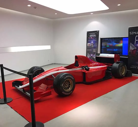 Participant pilotant le simulateur F1 VR By Evos sur chassis ARROWS pendant un événement corporate