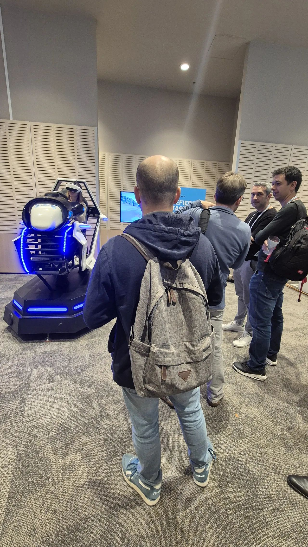 File d'attente de visiteurs B2B tech devant le simulateur ski VR sur le stand Snowflake