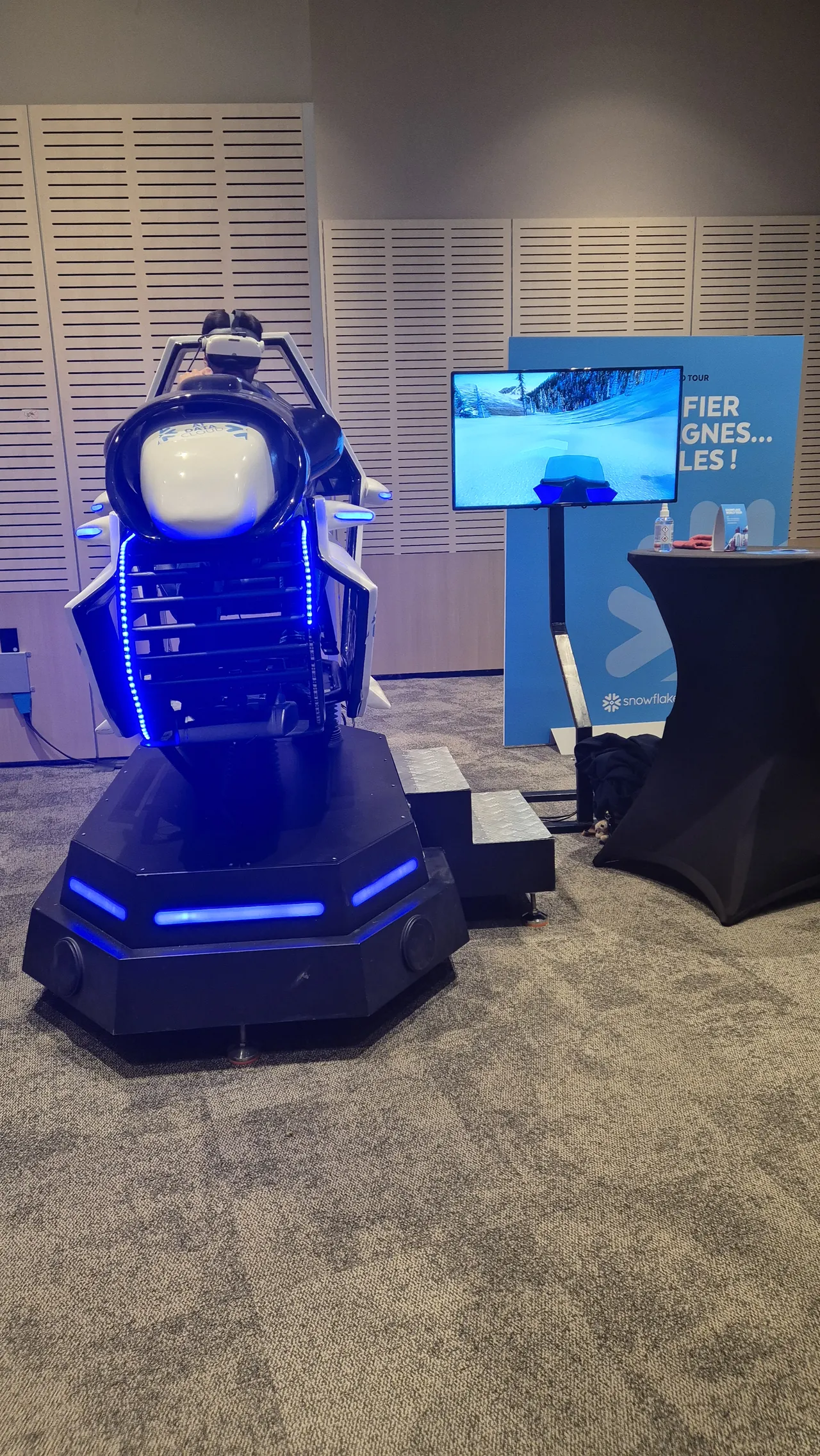 Plateforme ski VR à halo LED bleu allumée avec écran de retransmission en arrière-plan sur le stand