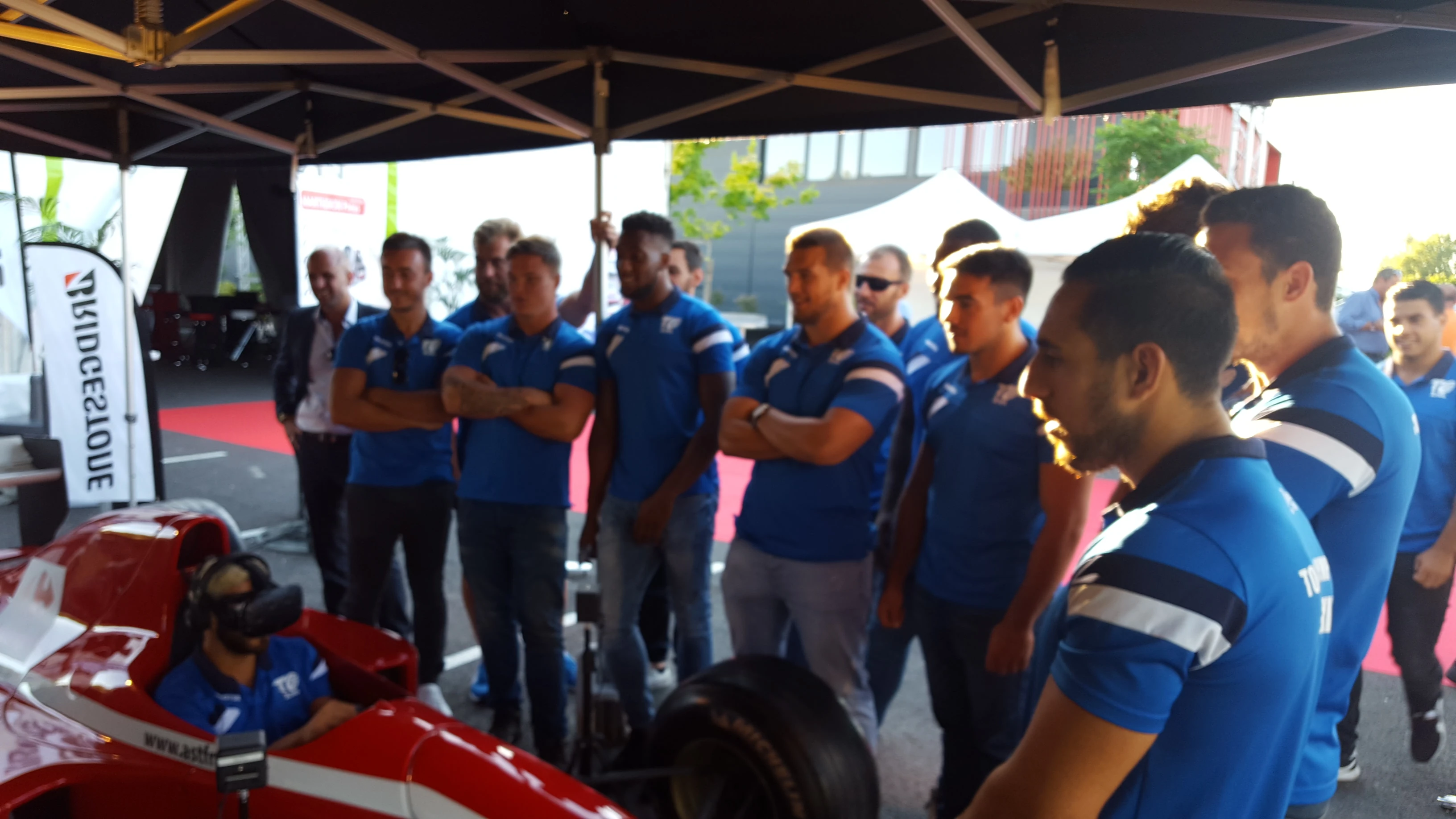 Joueurs de l'équipe Castres Olympique en délégation autour du simulateur F1 VR à l'inauguration Transports Sarrazain
