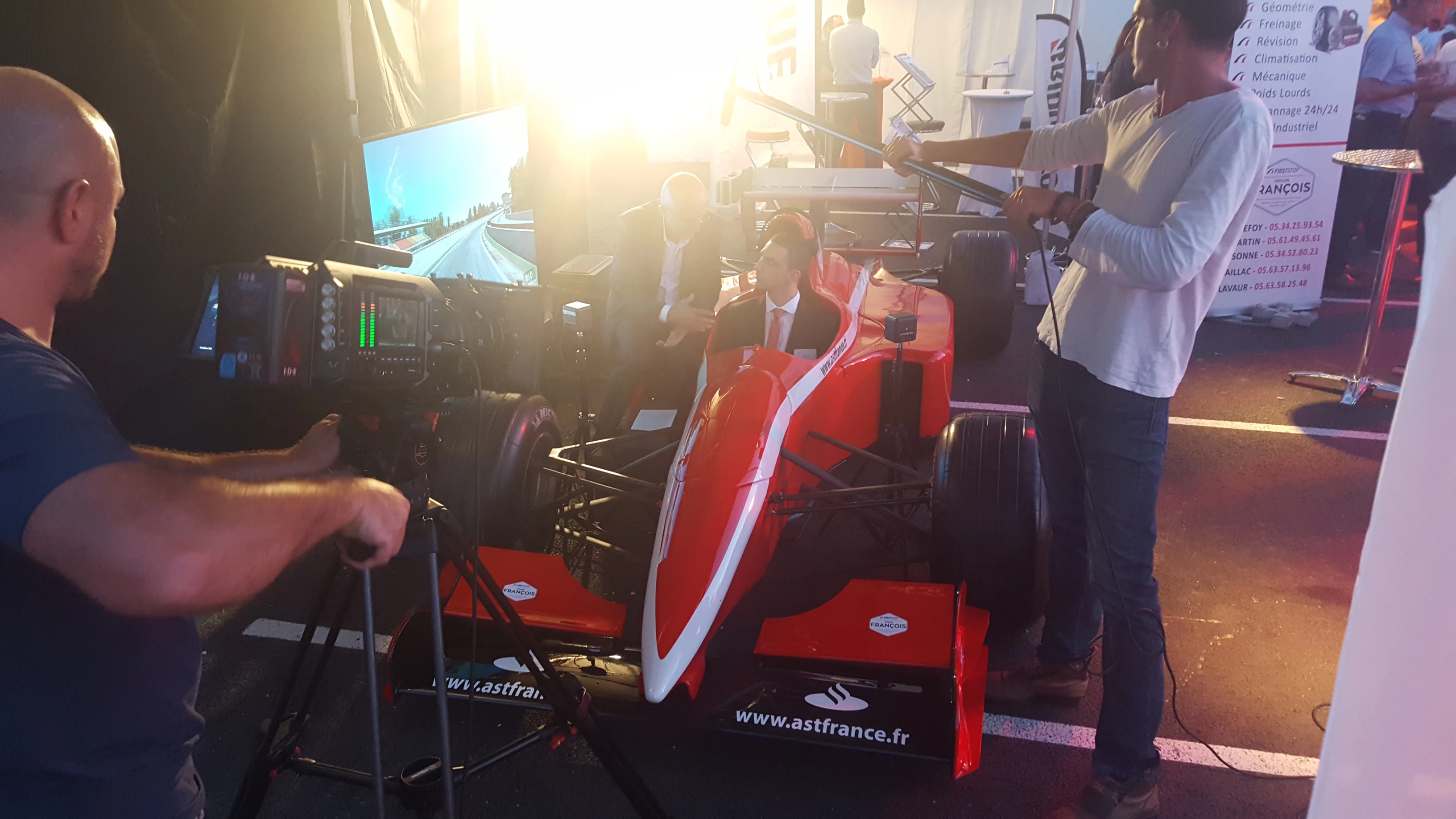 Équipe télévisée régionale en tournage autour du simulateur F1 VR à l'inauguration Transports Sarrazain