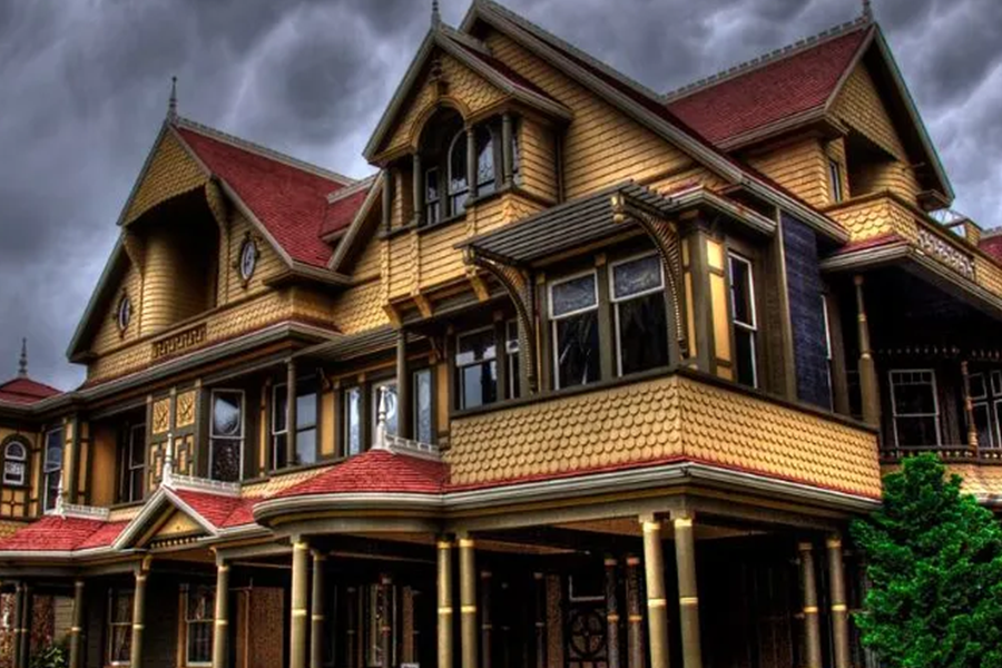 La maison Winchester sous un ciel orageux.