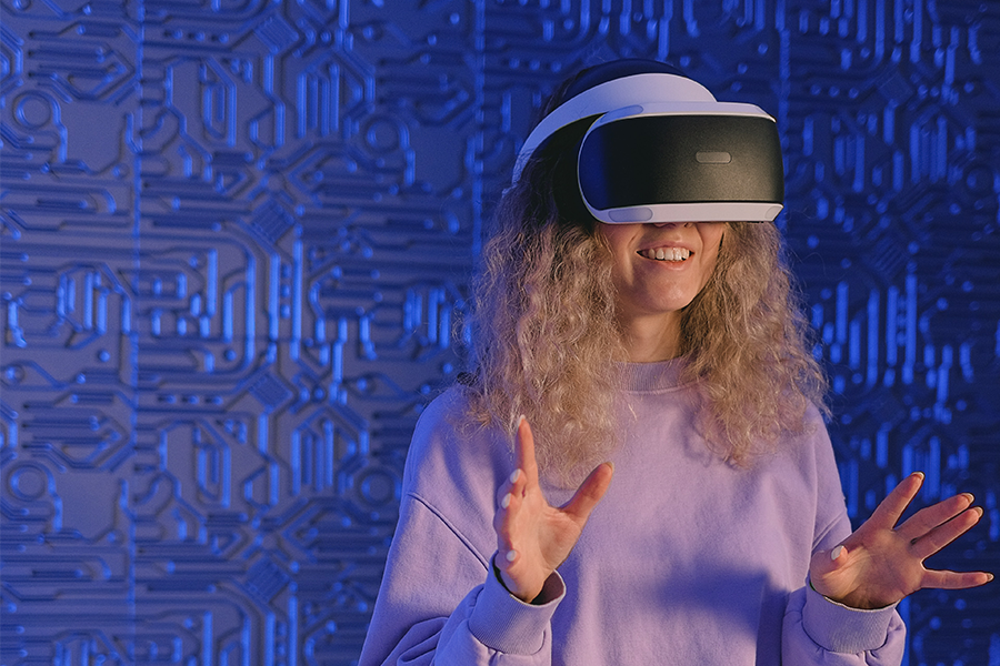 Une jeune femme souriante portant un casque de réalité virtuelle en train de faire une expérience d&#039;exploration.