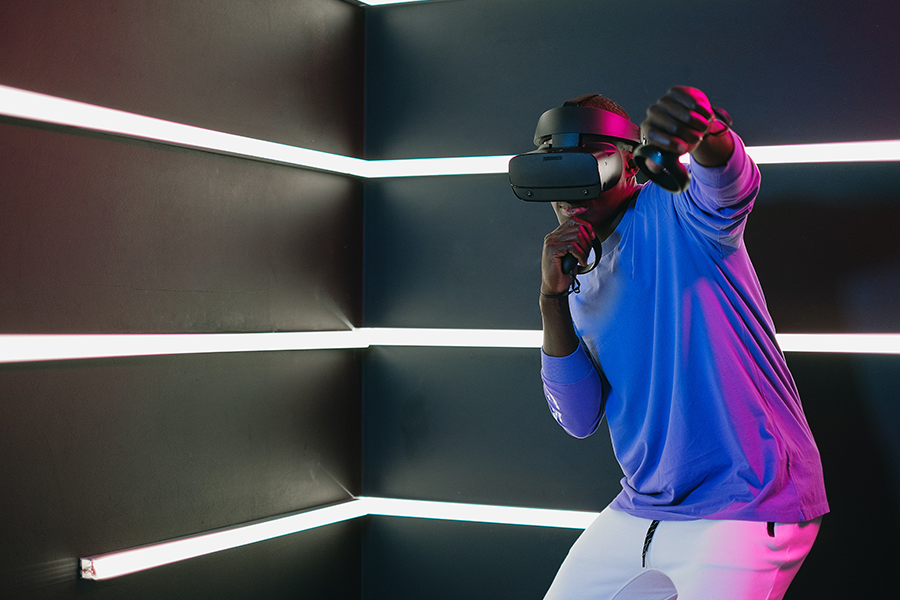Un jeune homme parisien portant un casque de réalité virtuelle dans une salle de réalité virtuelle.
